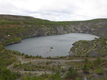 Scenic view of river against cloudy sky