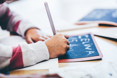 Close-up of childrens hand writing in school  