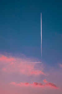 Low angle view of vapor trail against blue sky