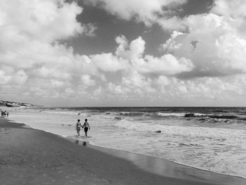 People walking on sand at beach