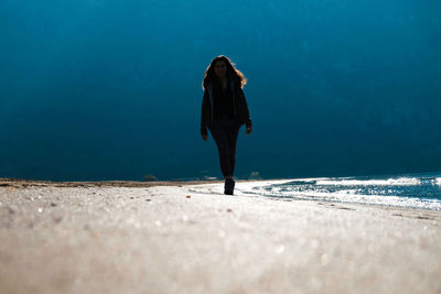 Rear view of woman standing on beach