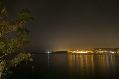 Illuminated lake against sky at night