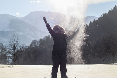 Rear view of girl standing on snow covered land