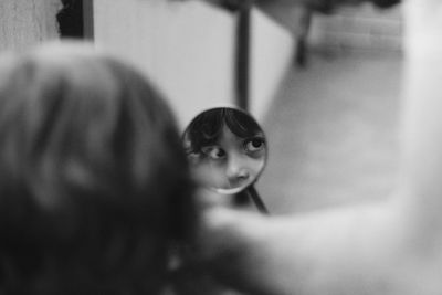 Reflecting of boy on side-view mirror