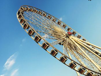 Low angle view of ferris wheel against clear blue sky