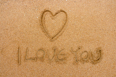 Heart shape with text on sand