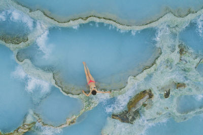High angle view of teenage girl wearing bikini while relaxing in hot spring