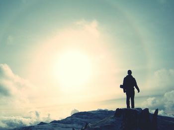 Silhouette man standing on mountain against sky during sunset