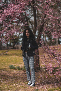 Portrait of woman standing by flower tree