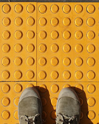 Low section of man standing on tiled floor