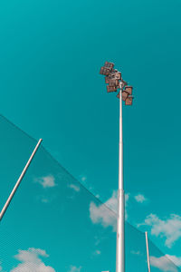 Low angle view of floodlight against blue sky