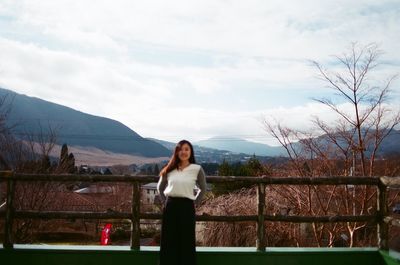 Portrait of woman standing on mountain against sky