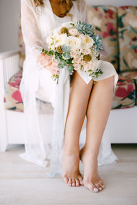 Low section of woman with white flowers