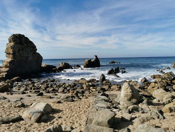 Rocks on beach against sky