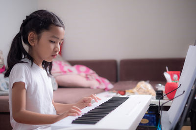 Girl playing piano at home