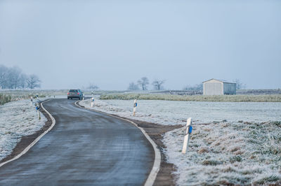 Scenic view of winding country road against clear sky