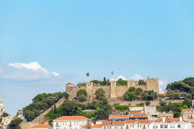 Buildings in city against blue sky