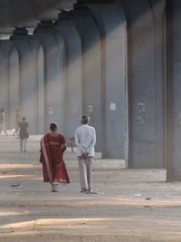 Rear view of people walking on street in city