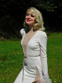 Portrait of a smiling young woman standing in grass