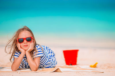 Woman wearing sunglasses on table at beach