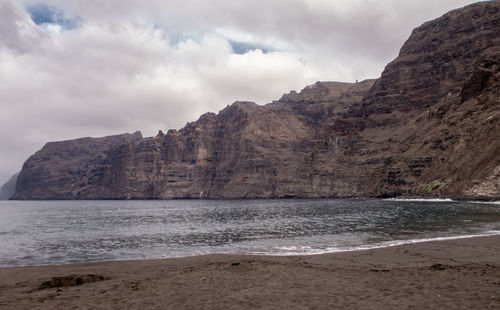 Scenic view of sea and mountains against sky