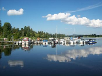 Boats moored in lake against sky