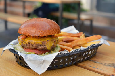 Tasty burger with fried potatoe sticks