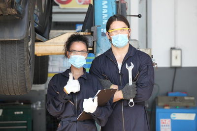 Portrait of mechanics standing in workshop