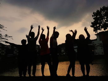 Silhouette people against sky during sunset