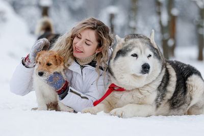 Woman with dogs in snow during winter