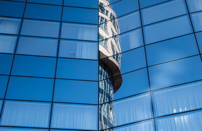 Low angle view of modern building against blue sky