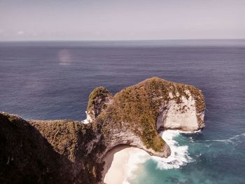 High angle view of rock formation in sea against sky