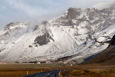 A road in iceland heading towards a snowcapped mountain