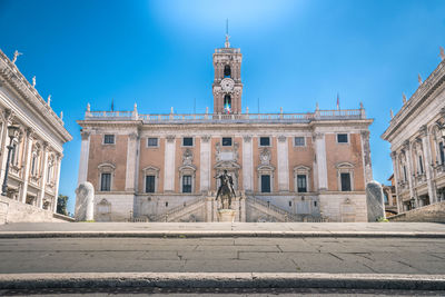 Buildings in city against blue sky