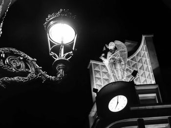 Low angle view of illuminated lamp at night