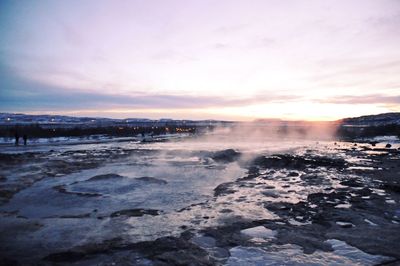 Strokkur geyser against sky during sunset