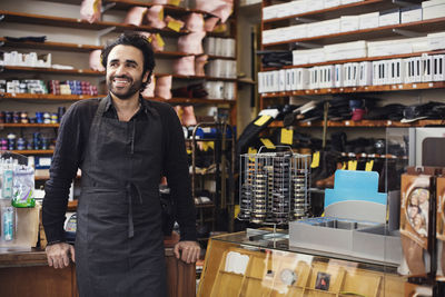 Smiling man standing in shoe repair store