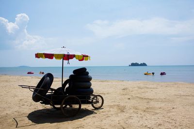 View of man sitting on beach against sky