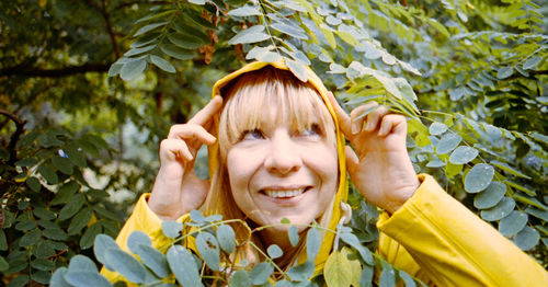 Close-up of smiling woman amidst plant