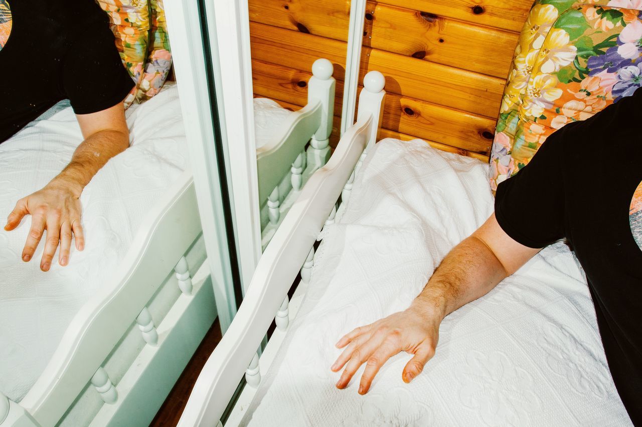 HIGH ANGLE VIEW OF WOMAN STANDING ON BED