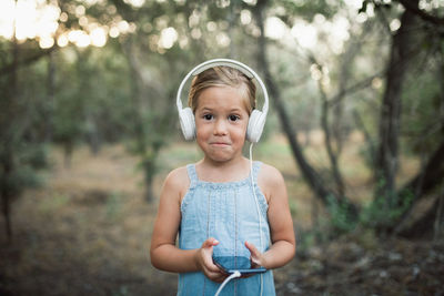 Portrait of cute girl standing on tree