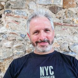 Portrait of man standing against brick wall