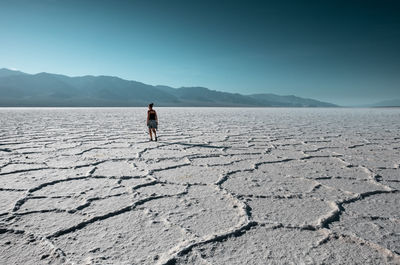 Rear view of woman standing on salt flat