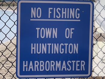 Close-up of warning sign on chainlink fence