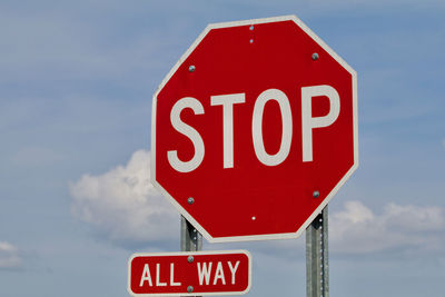 Low angle view of road sign against sky