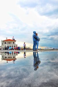 People standing on lake against sky