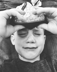 Close-up portrait of smiling boy holding camera