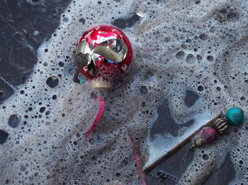 High angle view of abandoned bauble and beads in surf