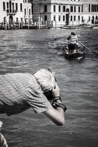 Rear view of man photographing on grand canal