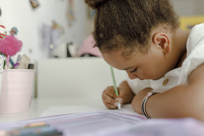 Girl drawing on paper at desk